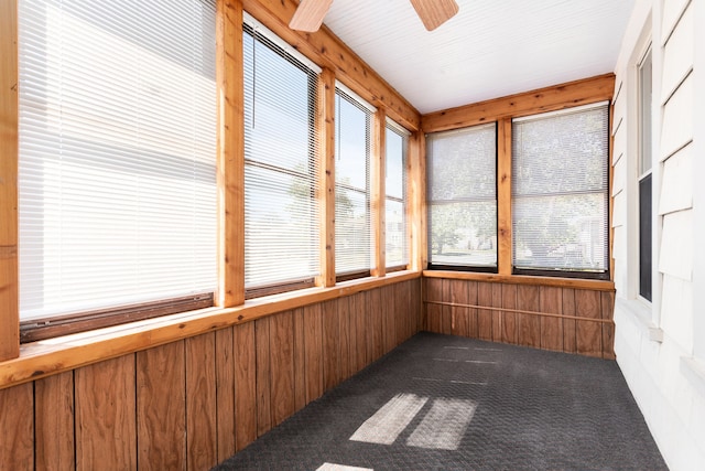 unfurnished sunroom featuring ceiling fan and a wealth of natural light