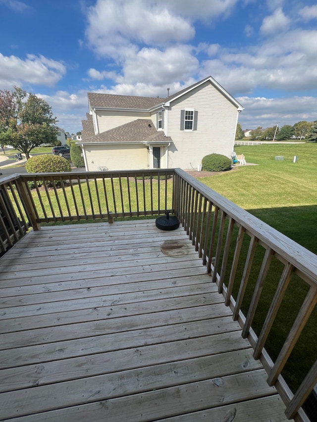 wooden deck featuring a lawn