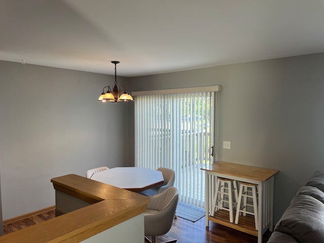 dining room with dark hardwood / wood-style flooring and a chandelier