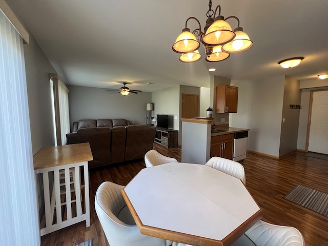 dining space featuring sink, dark wood-type flooring, and ceiling fan with notable chandelier