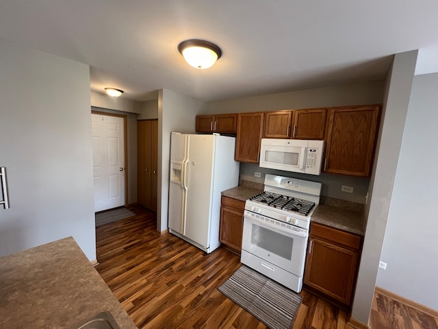 kitchen featuring white appliances and dark hardwood / wood-style floors