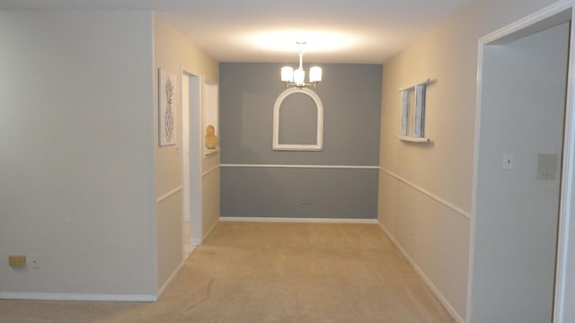 hallway with a notable chandelier and light carpet