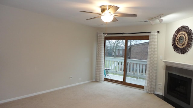 unfurnished living room featuring ceiling fan, light colored carpet, and track lighting