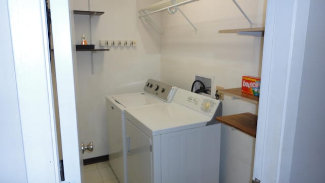 laundry room featuring washer and clothes dryer and light tile patterned floors