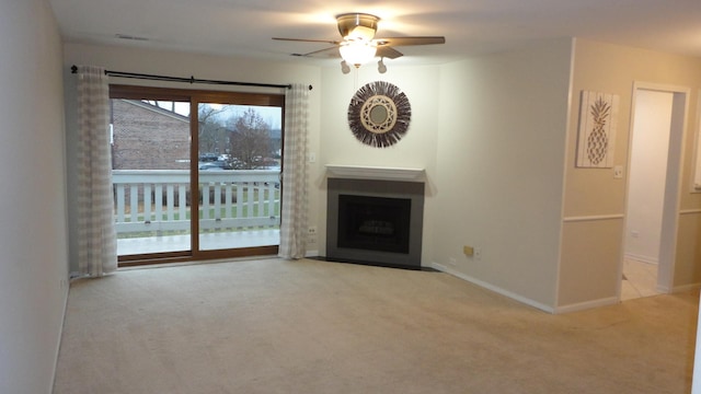 unfurnished living room featuring light carpet and ceiling fan