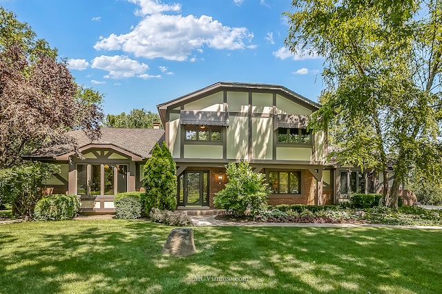 rear view of property featuring a lawn