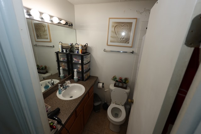 bathroom with tile patterned flooring, vanity, and toilet