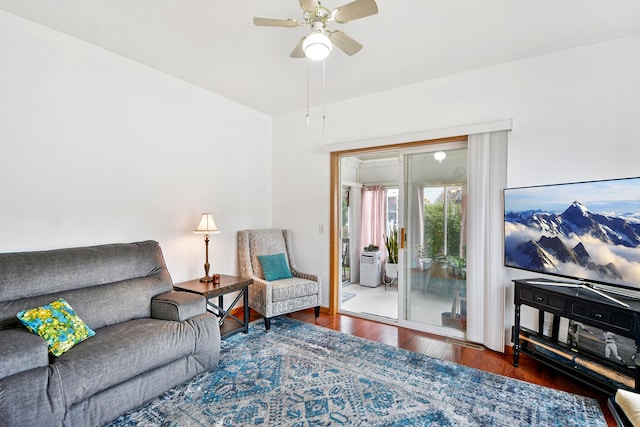 living room with ceiling fan and dark wood-type flooring