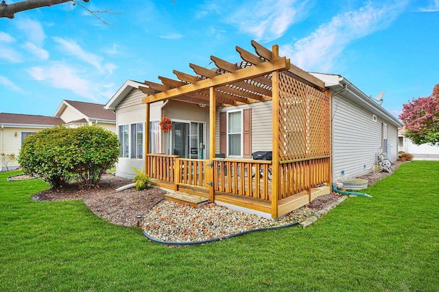 back of property featuring a pergola, a wooden deck, and a yard