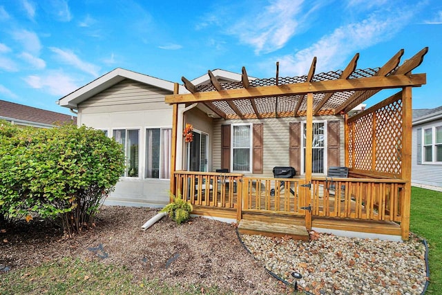 rear view of house featuring a pergola and a deck