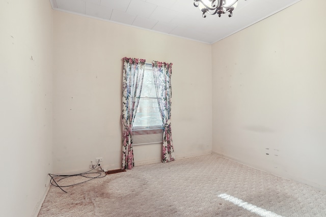 spare room with light carpet, a notable chandelier, and crown molding