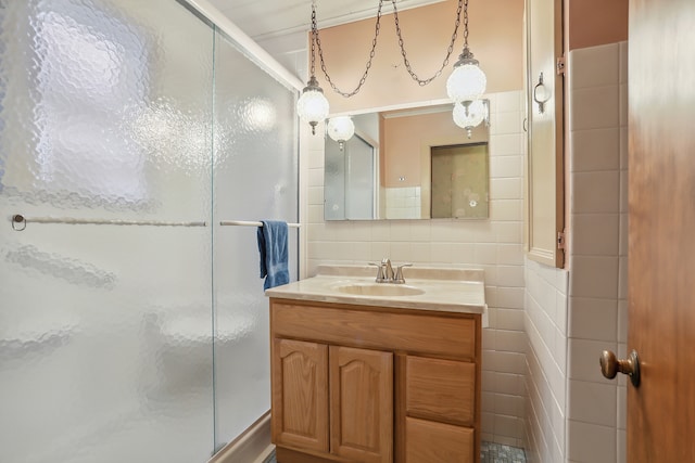 bathroom with vanity, a shower with shower door, tile walls, and backsplash