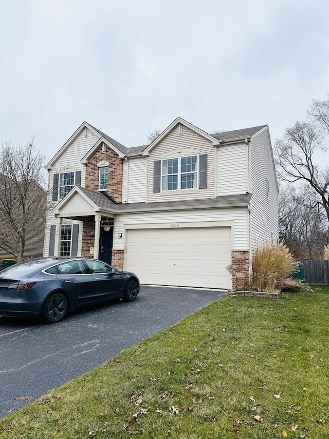 view of property featuring a front lawn and a garage