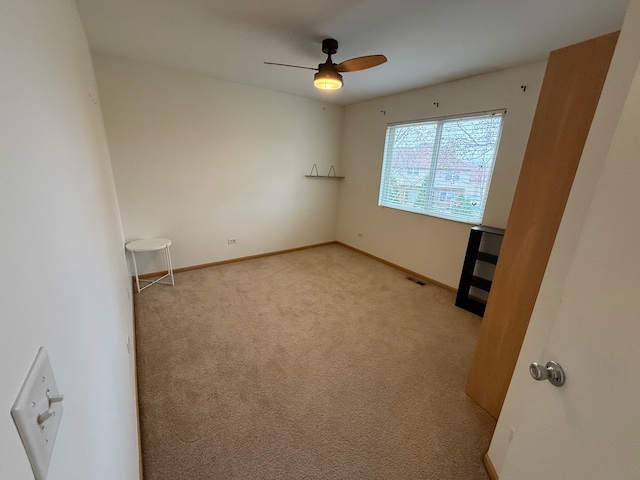 carpeted spare room with ceiling fan