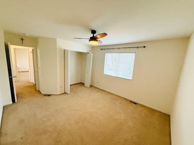 unfurnished bedroom featuring ceiling fan and light colored carpet