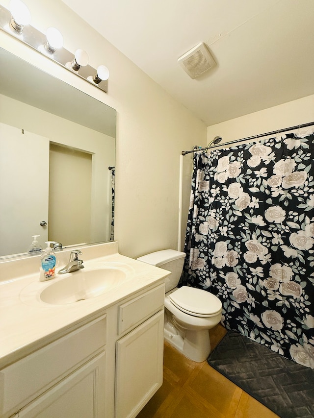 bathroom with vanity, toilet, and curtained shower