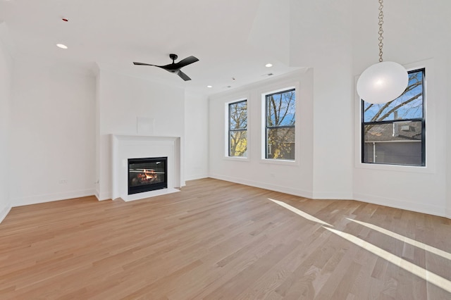 unfurnished living room with ceiling fan, light hardwood / wood-style floors, and ornamental molding