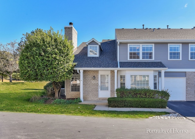 view of front of house featuring a garage and a front lawn