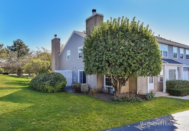 view of property exterior with central AC unit and a yard