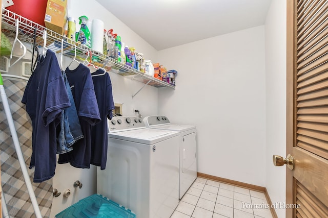 laundry area with light tile patterned floors and washing machine and clothes dryer