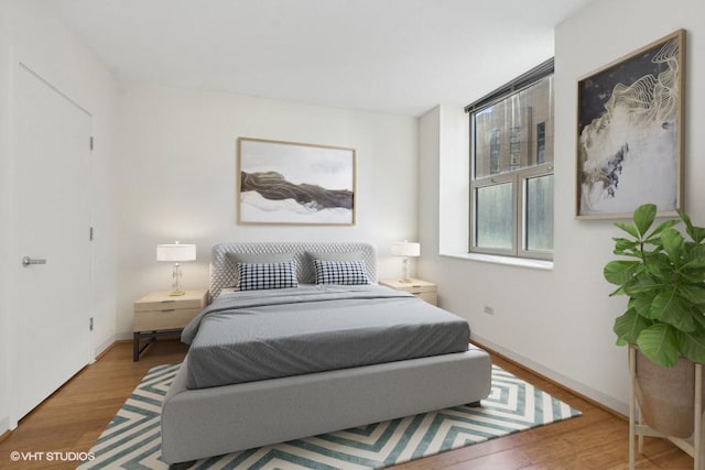 bedroom featuring baseboards and wood finished floors