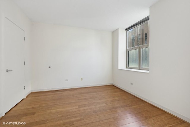 spare room with light wood-style flooring and baseboards