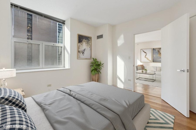 bedroom featuring visible vents and wood finished floors