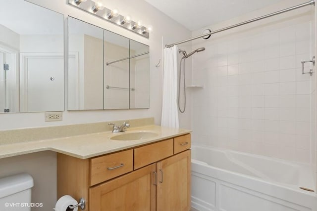 bathroom featuring vanity, toilet, and shower / bath combo with shower curtain