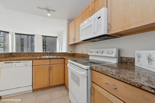 kitchen featuring light tile patterned floors, stone countertops, light brown cabinets, white appliances, and a sink