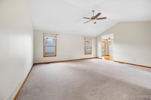 carpeted empty room featuring plenty of natural light, lofted ceiling, and ceiling fan