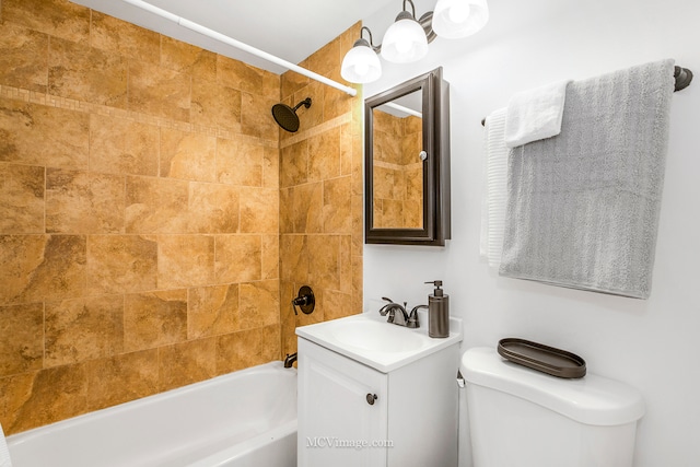 full bathroom with tiled shower / bath, vanity, and toilet