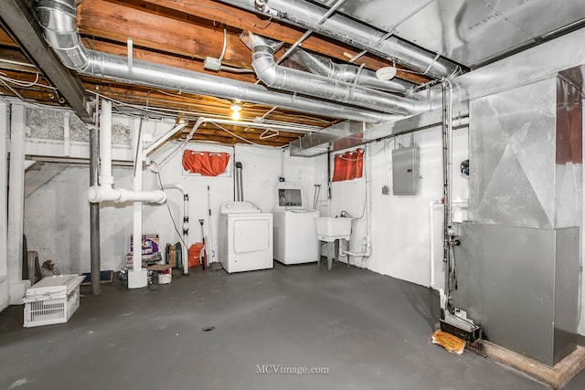 basement with sink, electric panel, and washing machine and clothes dryer