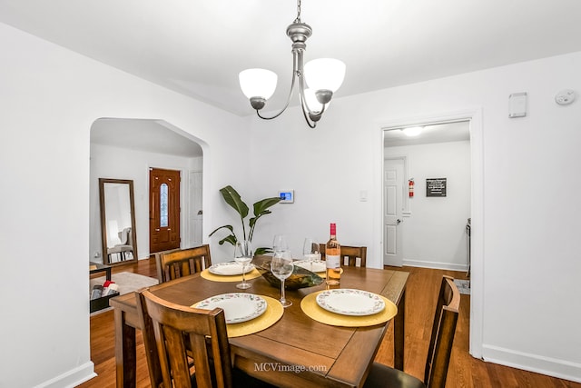 dining area featuring wood-type flooring and a chandelier