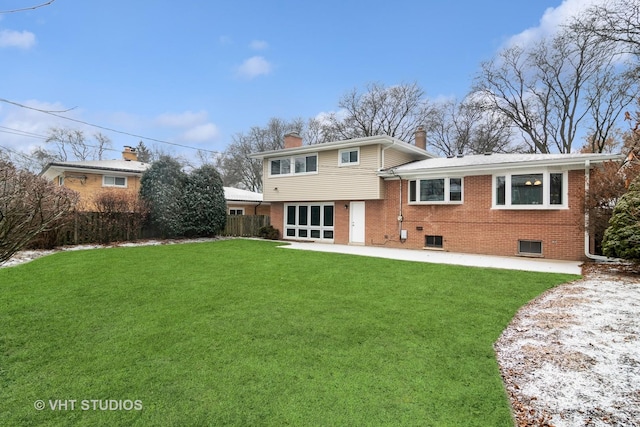 rear view of property featuring a lawn