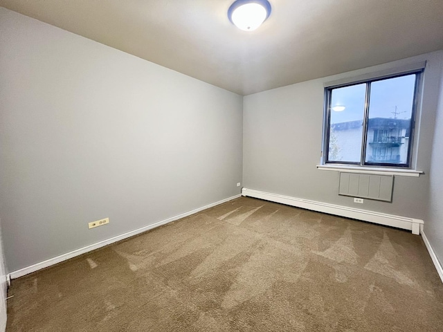 carpeted spare room featuring a baseboard radiator