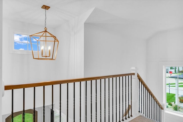 corridor with a chandelier and an upstairs landing