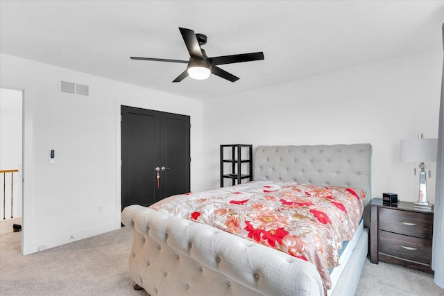 bedroom featuring a closet, visible vents, light carpet, ceiling fan, and baseboards