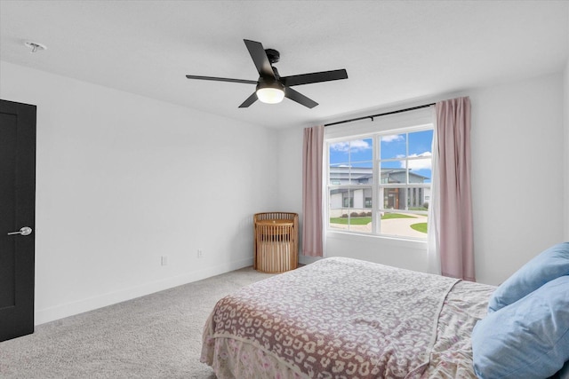 carpeted bedroom with ceiling fan and baseboards