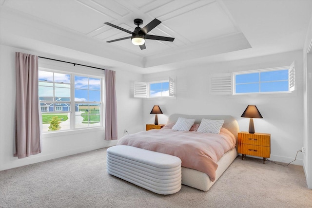 bedroom with light carpet, multiple windows, baseboards, and a raised ceiling