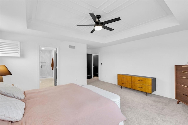 bedroom with visible vents, connected bathroom, light colored carpet, ceiling fan, and a tray ceiling