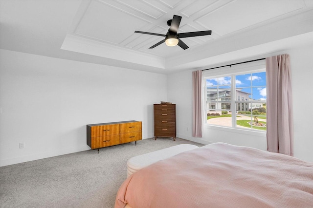 bedroom featuring baseboards, a raised ceiling, a ceiling fan, and light colored carpet