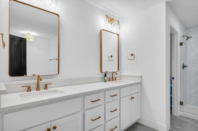 bathroom with double vanity, a shower stall, baseboards, and a sink