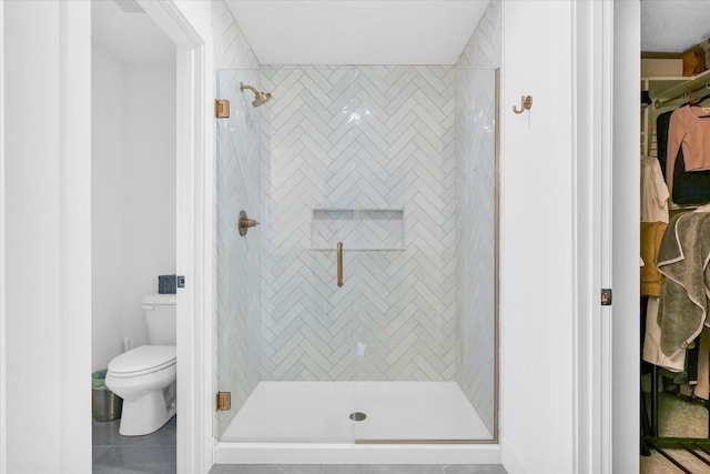 full bathroom with toilet, a shower stall, and tile patterned floors