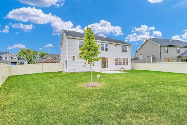 back of property featuring a yard, a fenced backyard, and a residential view