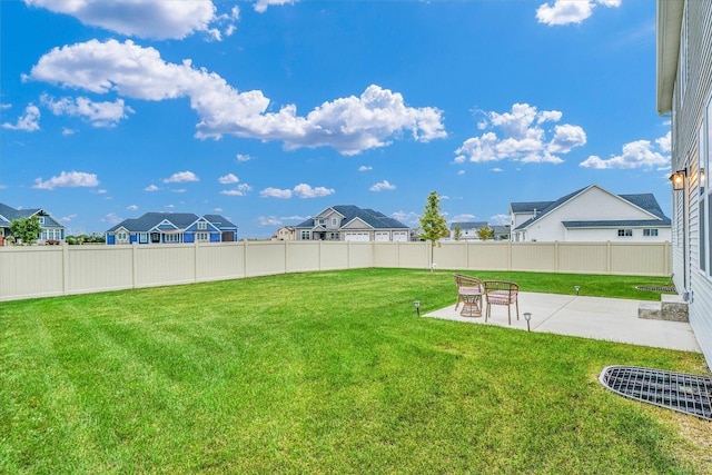 view of yard featuring a fenced backyard, a residential view, and a patio