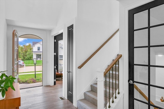 entrance foyer with visible vents, light wood finished floors, and stairs