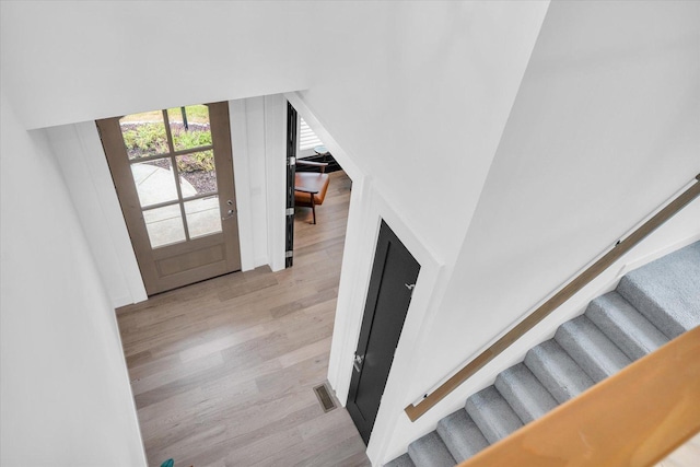 staircase with visible vents and wood finished floors