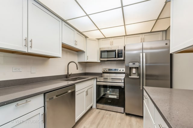 kitchen featuring white cabinets, sink, stainless steel appliances, and light hardwood / wood-style flooring