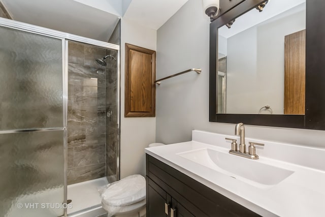 bathroom with toilet, an enclosed shower, and vanity