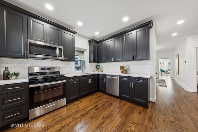 kitchen with decorative backsplash, ornamental molding, stainless steel appliances, sink, and dark hardwood / wood-style floors